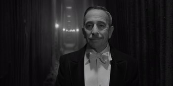 Movie still from “El Conde” (2023), directed by Pablo Larraín – An older man in a suit and a bow tie; Close Up shot, Low angle