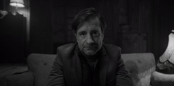 Movie still from “El Conde” (2023), directed by Pablo Larraín – Black and white photograph of a man in a suit and tie; Close Up shot, Over the shoulder angle