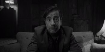 Movie still from “El Conde” (2023), directed by Pablo Larraín – Black and white photograph of a man in a suit; Close Up shot, Over the shoulder angle