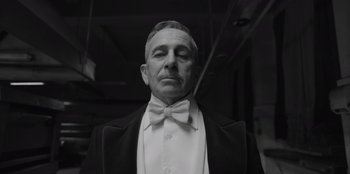 Movie still from “El Conde” (2023), directed by Pablo Larraín – An old man in a suit and a bow tie; Close Up shot, Low angle
