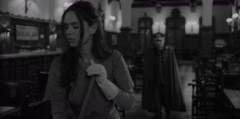 Movie still from “El Conde” (2023), directed by Pablo Larraín – A woman holding a cane in front of a man in a uniform; Medium shot, Low angle