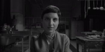 Movie still from “El Conde” (2023), directed by Pablo Larraín – Black and white photograph of a woman with short hair; Close Up shot, Over the shoulder angle