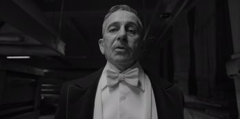 Movie still from “El Conde” (2023), directed by Pablo Larraín – An older man wearing a white bow tie; Close Up shot, Low angle