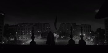 Movie still from “El Conde” (2023), directed by Pablo Larraín – A person standing in front of a building at night; Extreme Wide shot, Low angle
