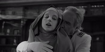 Movie still from “El Conde” (2023), directed by Pablo Larraín – An older man kissing a young woman in a nun's outfit; Close Up shot, Low angle