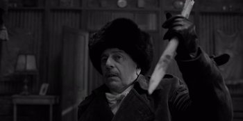 Movie still from “El Conde” (2023), directed by Pablo Larraín – A man holding a knife in his hand and wearing a fur hat; Close Up shot, Low angle