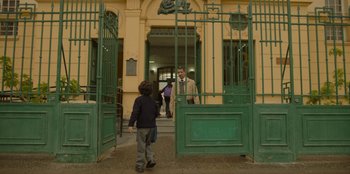 Movie still from “El Conde” (2023), directed by Pablo Larraín – A man standing in front of an open door; Wide shot, Low angle
