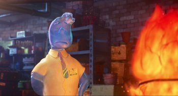 Movie still from “Elemental” (2023), directed by Peter Sohn – A statue of a man in a yellow shirt with a blue tie; Medium shot, Low angle