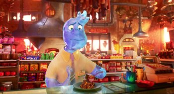 Movie still from “Elemental” (2023), directed by Peter Sohn – An animated character in a restaurant with a plate of food on the table; Medium shot, Over the shoulder angle