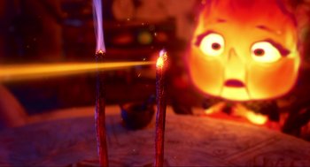 Movie still from “Elemental” (2023), directed by Peter Sohn – Two lit candles sitting on a table in front of a blurry face; Close Up shot, Over the shoulder angle