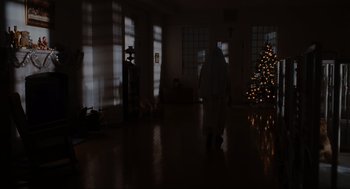 Movie still from “Elf” (2003), directed by Jon Favreau – A person walking in a living room with a christmas tree; Extreme Wide shot, Low angle