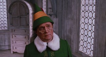 Movie still from “Elf” (2003), directed by Jon Favreau – An old man dressed as buddy the elf; Medium shot, Over the shoulder angle