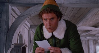 Movie still from “Elf” (2003), directed by Jon Favreau – A man dressed as buddy the elf holding a piece of paper; Medium shot, Low angle