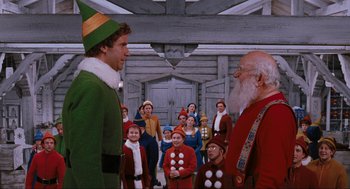 Movie still from “Elf” (2003), directed by Jon Favreau – A group of people dressed up as santa and elf; Medium shot, Over the shoulder angle