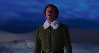 Movie still from “Elf” (2003), directed by Jon Favreau – A man wearing a green jacket and a white hat; Medium shot, Low angle