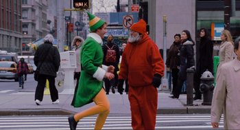 Movie still from “Elf” (2003), directed by Jon Favreau – Two men dressed as santa clause and the elf are crossing the street; Wide shot, Over the shoulder angle