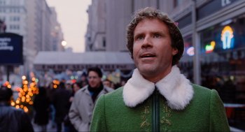 Movie still from “Elf” (2003), directed by Jon Favreau – A person wearing a green coat; Medium shot, Over the shoulder angle