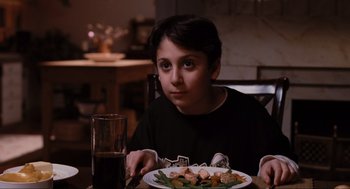 Movie still from “Elf” (2003), directed by Jon Favreau – A boy sitting at a table with a plate of food in front of him; Close Up shot, High angle