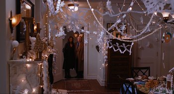 Movie still from “Elf” (2003), directed by Jon Favreau – A man and a woman standing in front of christmas decorations; Wide shot, High angle