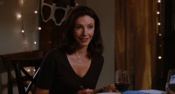Movie still from “Elf” (2003), directed by Jon Favreau – A woman sitting at a table with a glass of red wine; Close Up shot, Over the shoulder angle