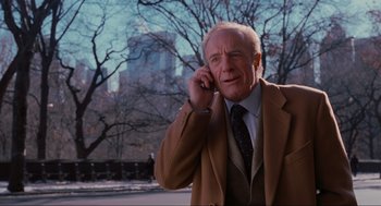 Movie still from “Elf” (2003), directed by Jon Favreau – An older man talking on a cell phone in front of trees; Medium shot, Low angle