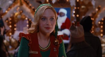Movie still from “Elf” (2003), directed by Jon Favreau – A woman wearing a green and red elf outfit; Close Up shot, Over the shoulder angle