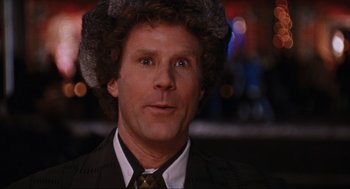 Movie still from “Elf” (2003), directed by Jon Favreau – A person wearing a suit and a fur hat; Close Up shot, Over the shoulder angle