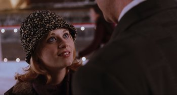 Movie still from “Elf” (2003), directed by Jon Favreau – A woman wearing a leopard print hat and a man in a brown suit; Close Up shot, Over the shoulder angle