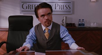 Movie still from “Elf” (2003), directed by Jon Favreau – A man sitting at a desk in a suit and tie; Medium shot, High angle