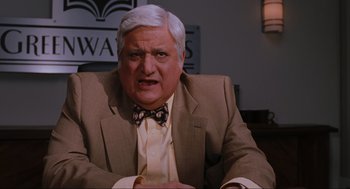 Movie still from “Elf” (2003), directed by Jon Favreau – An older man wearing a suit and a bow tie; Close Up shot, Over the shoulder angle