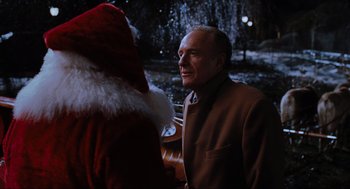Movie still from “Elf” (2003), directed by Jon Favreau – An older man wearing a suit talking to a santa clause; Close Up shot, Over the shoulder angle