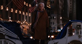 Movie still from “Elf” (2003), directed by Jon Favreau – A woman standing in front of christmas lights; Wide shot, Over the shoulder angle