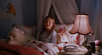 Movie still from “Elf” (2003), directed by Jon Favreau – A little girl sitting in her bed smiling; Medium shot, High angle