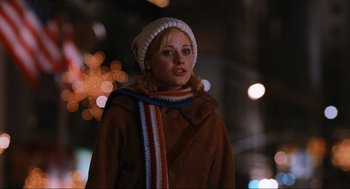 Movie still from “Elf” (2003), directed by Jon Favreau – A woman in a brown coat and a white hat; Close Up shot, Over the shoulder angle