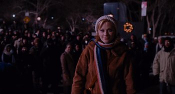 Movie still from “Elf” (2003), directed by Jon Favreau – A woman wearing a brown coat and a white hat; Medium shot, Over the shoulder angle