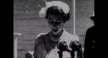 Movie still from “Elizabeth: A Portrait in Part(s)” (2022), directed by Roger Michell – An old black and white photo of a woman with a flower in her hair; Close Up shot, Low angle