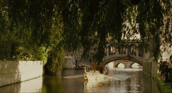 Movie still from “Elizabeth: A Portrait in Part(s)” (2022), directed by Roger Michell – A group of swans floating on a lake near a bridge; Extreme Wide shot, High angle