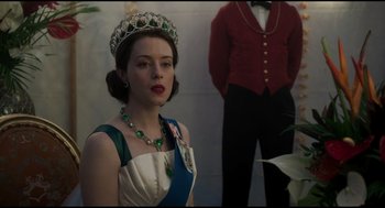 Movie still from “Elizabeth: A Portrait in Part(s)” (2022), directed by Roger Michell – A woman wearing a tiara and a crown; Medium shot, Over the shoulder angle