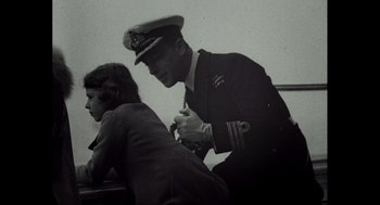 Movie still from “Elizabeth: A Portrait in Part(s)” (2022), directed by Roger Michell – An old black and white photo of a man and a young girl; Medium shot, Over the shoulder angle