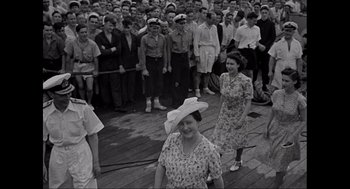 Movie still from “Elizabeth: A Portrait in Part(s)” (2022), directed by Roger Michell – A group of people standing on top of a boat; Wide shot, High angle