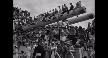 Movie still from “Elizabeth: A Portrait in Part(s)” (2022), directed by Roger Michell – A group of men sitting on top of bleachers; Extreme Wide shot, High angle