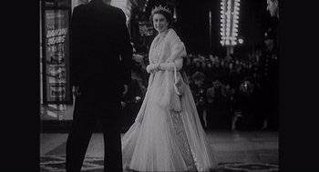 Movie still from “Elizabeth: A Portrait in Part(s)” (2022), directed by Roger Michell – An old photo of a woman in a long dress; Medium shot, Low angle