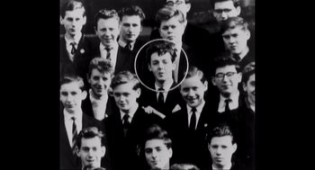 Movie still from “Elizabeth: A Portrait in Part(s)” (2022), directed by Roger Michell – A black and white photo of a group of young men; Extreme Close Up shot, Overhead angle
