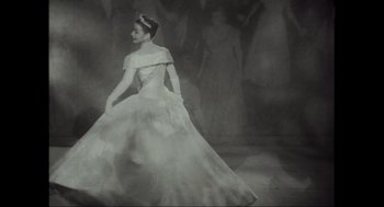 Movie still from “Elizabeth: A Portrait in Part(s)” (2022), directed by Roger Michell – A black and white photo of a woman in a ball gown; Wide shot, Low angle
