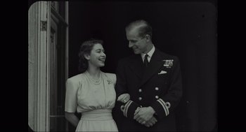 Movie still from “Elizabeth: A Portrait in Part(s)” (2022), directed by Roger Michell – An old photo of a man and a woman smiling; Medium shot, Low angle