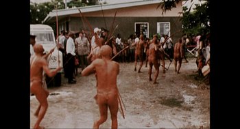 Movie still from “Elizabeth: A Portrait in Part(s)” (2022), directed by Roger Michell – A group of naked people are walking through the water; Wide shot, High angle