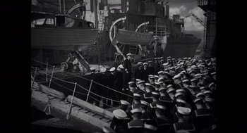 Movie still from “Elizabeth: A Portrait in Part(s)” (2022), directed by Roger Michell – A large group of men in navy uniforms standing on a boat; Extreme Wide shot, High angle