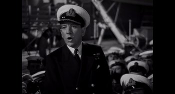 Movie still from “Elizabeth: A Portrait in Part(s)” (2022), directed by Roger Michell – A man in a military uniform standing in front of a group of people; Close Up shot, Low angle