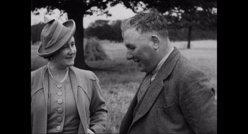 Movie still from “Elizabeth: A Portrait in Part(s)” (2022), directed by Roger Michell – An old photo of a man and a woman; Medium shot, Low angle