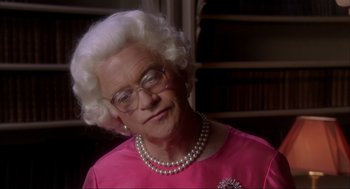 Movie still from “Elizabeth: A Portrait in Part(s)” (2022), directed by Roger Michell – An older woman wearing glasses and a pearl necklace; Close Up shot, Over the shoulder angle